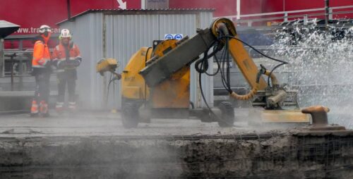 Hydrodemolition Equipment Removing Concrete Surface With Workers in Protective Gear
